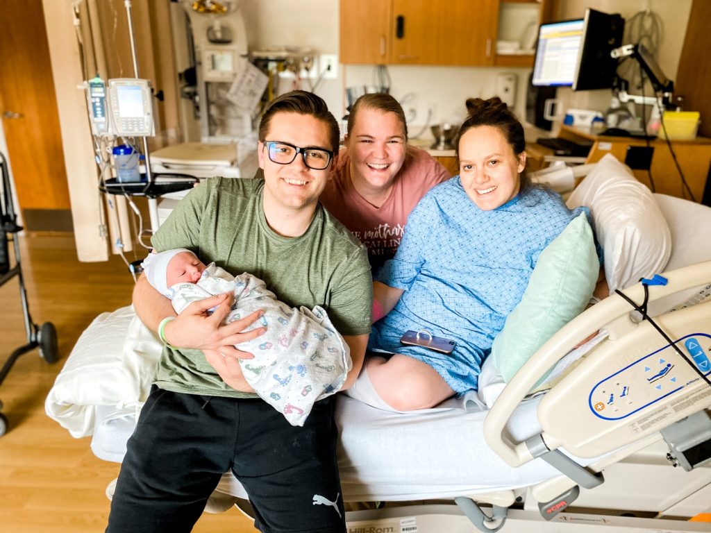 couple and doula with newborn after VBAC success